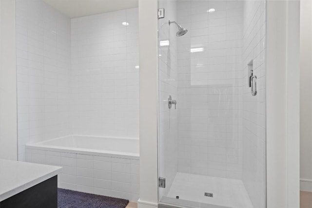 full bath featuring a shower stall, a washtub, and vanity