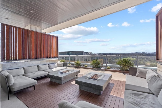 deck featuring an outdoor living space with a fire pit