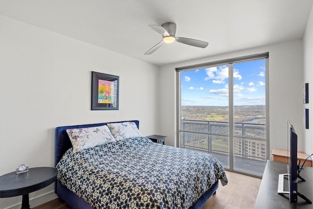 bedroom featuring access to outside, ceiling fan, and wood finished floors