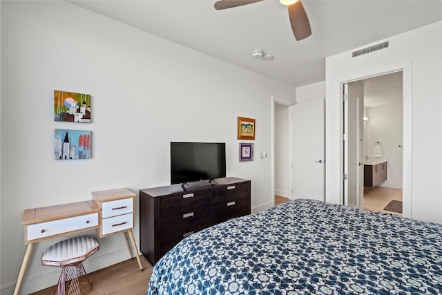 bedroom featuring visible vents, baseboards, and wood finished floors