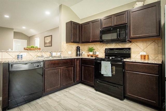 kitchen featuring dark brown cabinetry, lofted ceiling, decorative backsplash, black appliances, and a sink