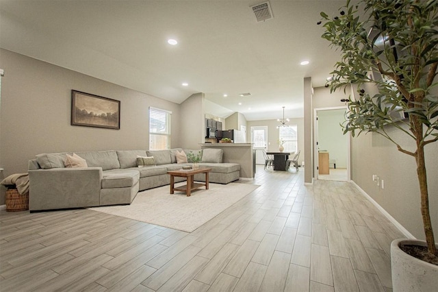 living room with light wood finished floors, visible vents, recessed lighting, and vaulted ceiling