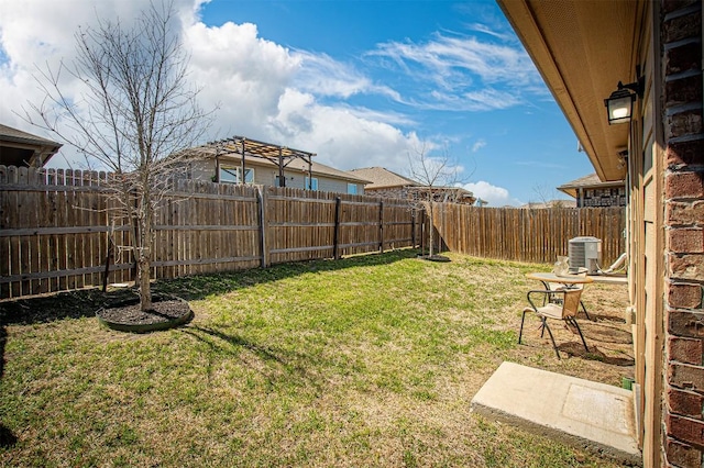 view of yard with central AC unit and a fenced backyard