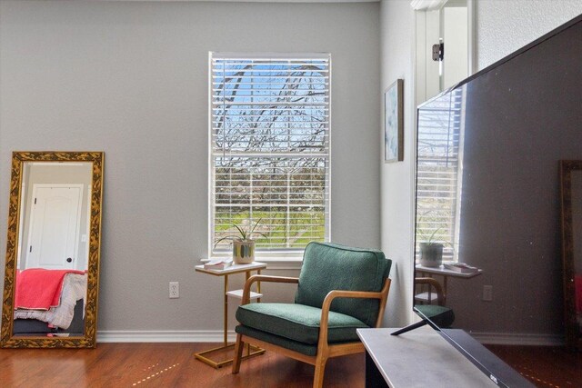 sitting room with baseboards and wood finished floors