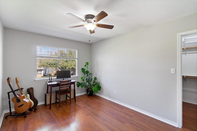 home office featuring a ceiling fan, baseboards, and wood finished floors