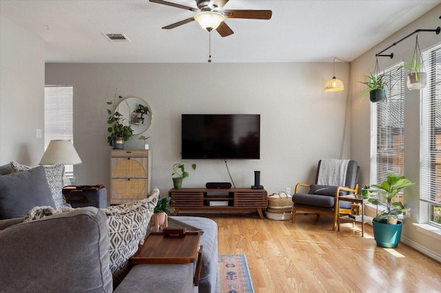 living room featuring ceiling fan, visible vents, and wood finished floors