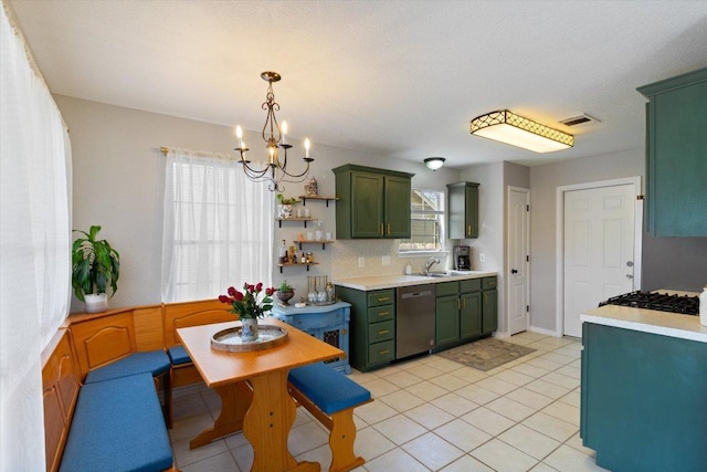 kitchen with a sink, stainless steel dishwasher, light countertops, and green cabinetry