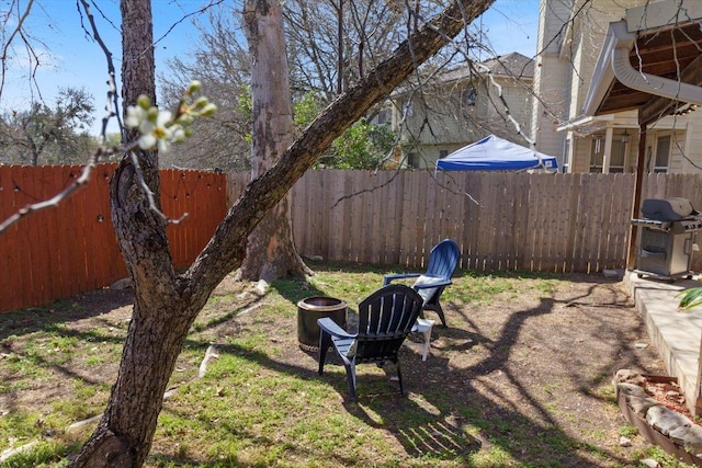 view of yard with fence and an outdoor fire pit