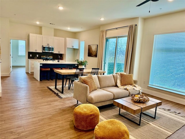 living room with light wood-style flooring, recessed lighting, and baseboards