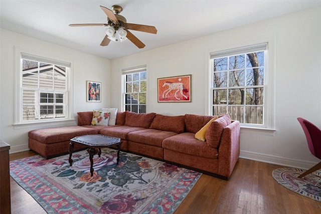 living area featuring a wealth of natural light, baseboards, and hardwood / wood-style flooring