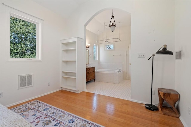 5902 Coventry Ln, Austin, TX 78723 - unfurnished bedroom with wood finished floors, arched walkways, and ensuite bathroom