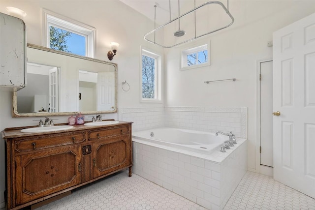 bathroom featuring a bath, a healthy amount of sunlight, and a sink