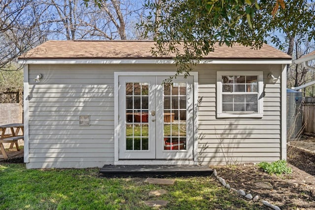 view of outbuilding featuring french doors, an outdoor structure, and fence