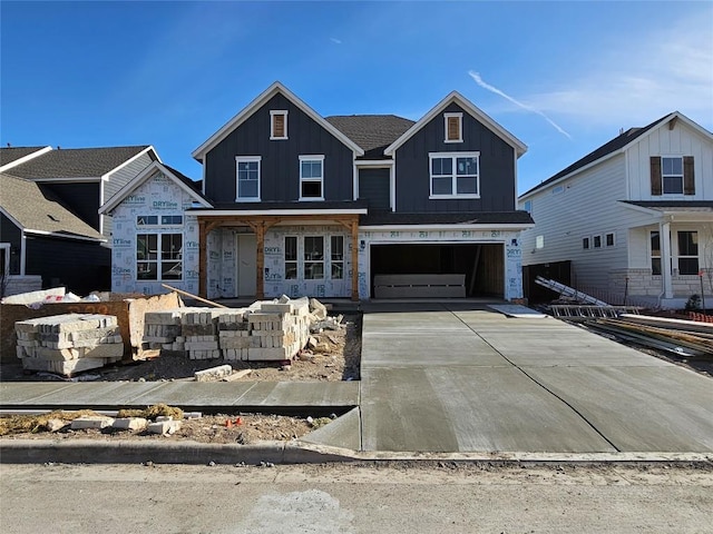 property in mid-construction with concrete driveway, a garage, and board and batten siding