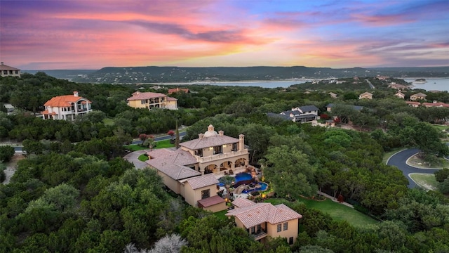 aerial view at dusk featuring a water view