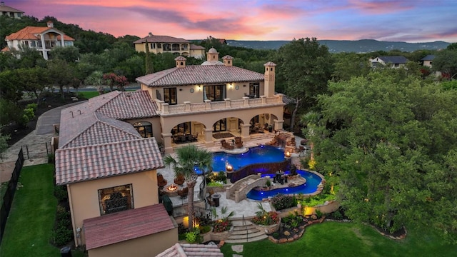 exterior space with stucco siding, a patio, a tile roof, and a balcony