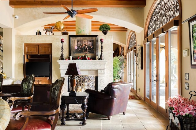 living area featuring french doors, arched walkways, light tile patterned flooring, a fireplace, and vaulted ceiling with beams