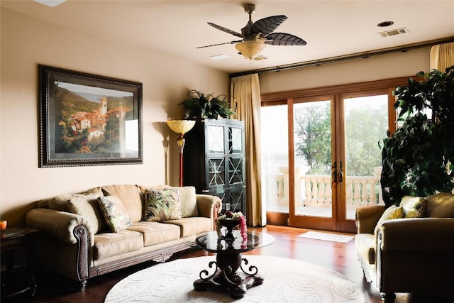 living room with dark wood-type flooring, french doors, visible vents, and ceiling fan