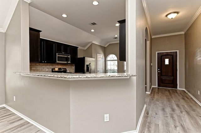 kitchen featuring crown molding, visible vents, light wood finished floors, and stainless steel appliances