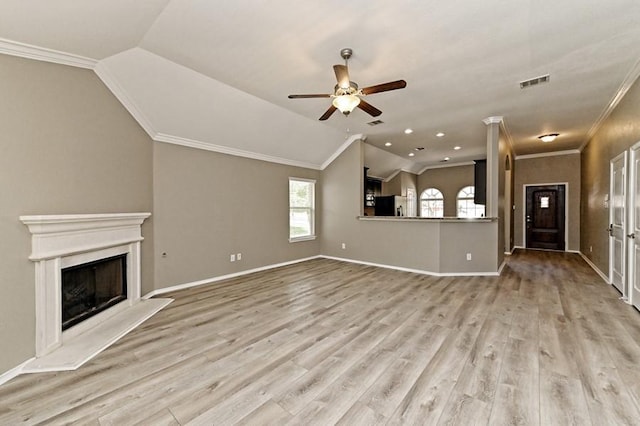 unfurnished living room with light wood finished floors, visible vents, a fireplace with raised hearth, and lofted ceiling