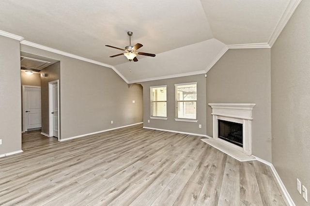 unfurnished living room with a fireplace with raised hearth, ornamental molding, a ceiling fan, wood finished floors, and vaulted ceiling