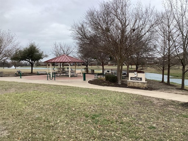 view of property's community with a gazebo, a water view, and a lawn