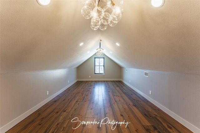 additional living space featuring dark wood finished floors, baseboards, and vaulted ceiling