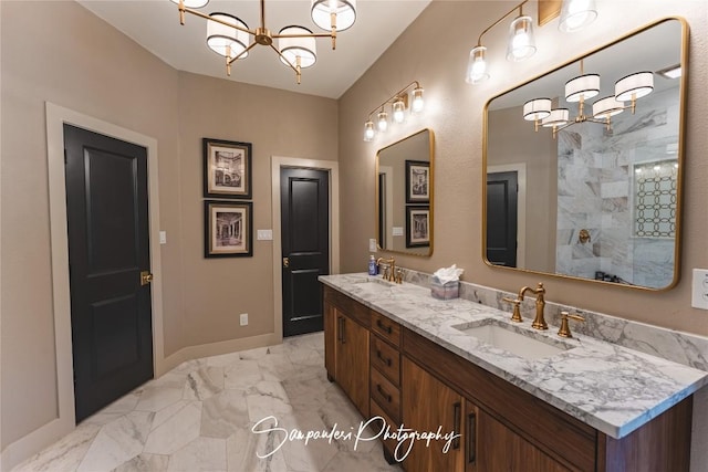 full bath featuring an inviting chandelier, double vanity, marble finish floor, and a sink