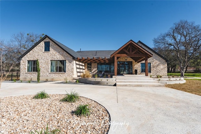 view of front of property featuring stone siding and concrete driveway