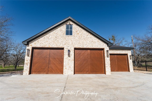 detached garage featuring fence