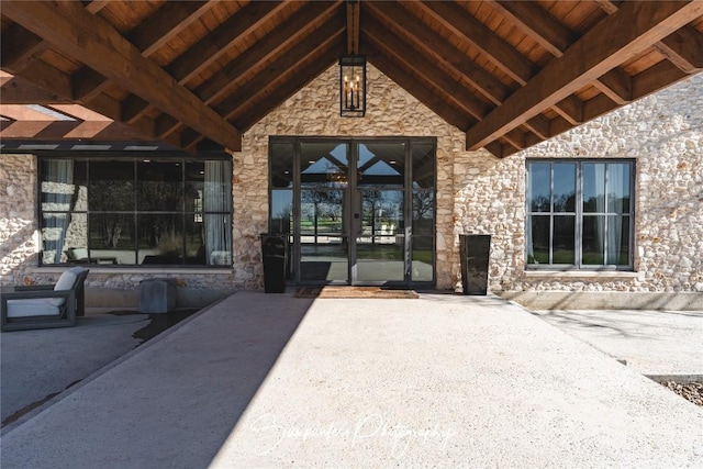 property entrance featuring french doors and stone siding