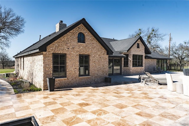 back of property featuring a patio and a chimney