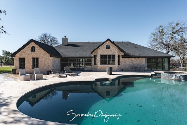 view of swimming pool with a pool with connected hot tub and a patio area