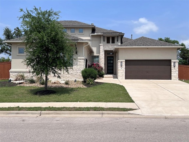 prairie-style home featuring stucco siding, a garage, stone siding, a front lawn, and concrete driveway