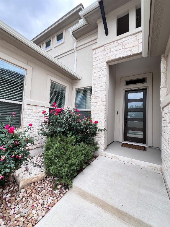 entrance to property with stone siding and stucco siding