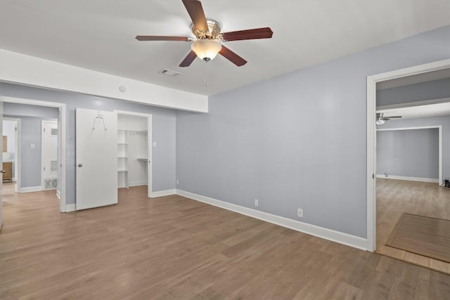 11705 Pollyanna Ave, Austin, TX 78753 - unfurnished bedroom featuring wood finished floors, a walk in closet, ceiling fan, and a closet