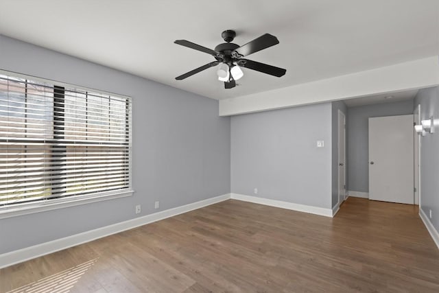 unfurnished room featuring a ceiling fan, baseboards, and wood finished floors