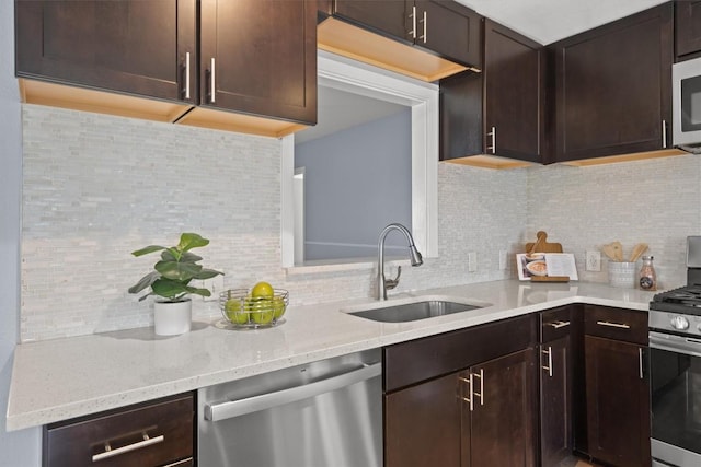 kitchen with dark brown cabinets, appliances with stainless steel finishes, and a sink