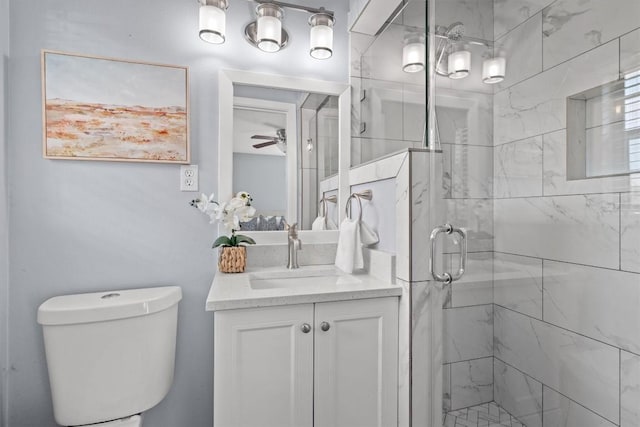 bathroom featuring vanity, a shower stall, toilet, and a ceiling fan