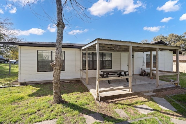 back of house with fence, a patio area, and a lawn