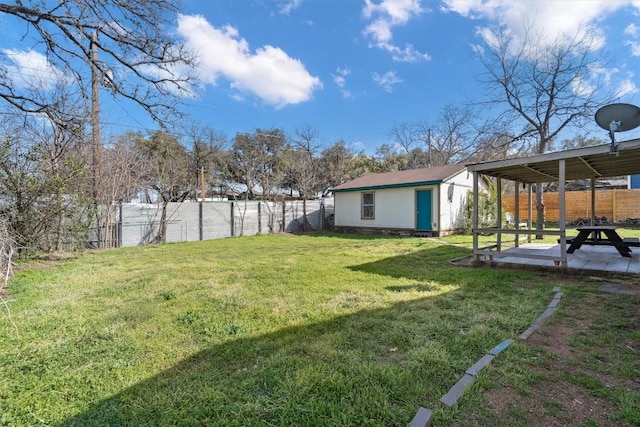 view of yard with an outbuilding, a fenced backyard, and a patio area