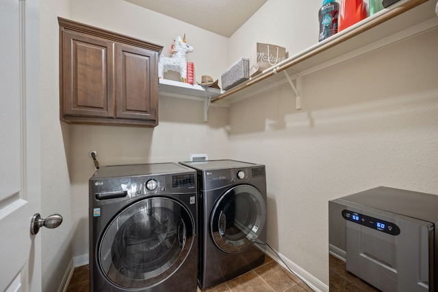 washroom featuring baseboards, independent washer and dryer, cabinet space, and tile patterned flooring