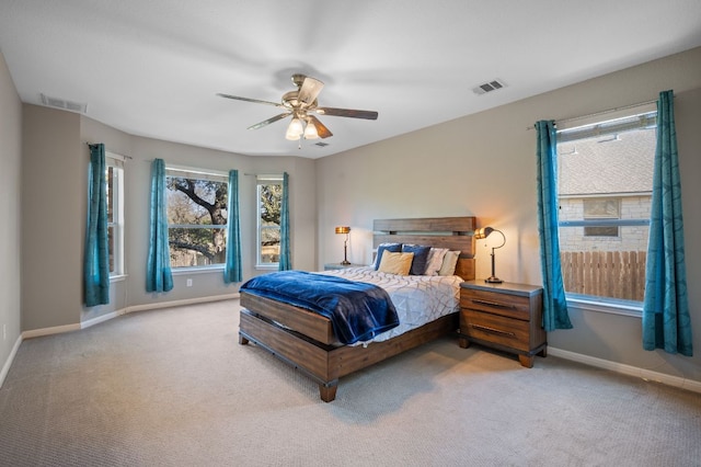 carpeted bedroom with visible vents, baseboards, and ceiling fan