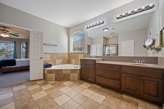 full bathroom with a shower stall, double vanity, ensuite bathroom, a bath, and a sink