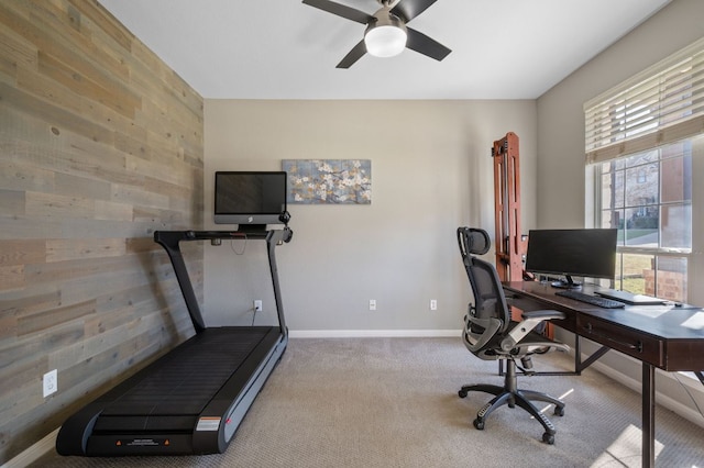 office space with ceiling fan, baseboards, carpet, and wood walls