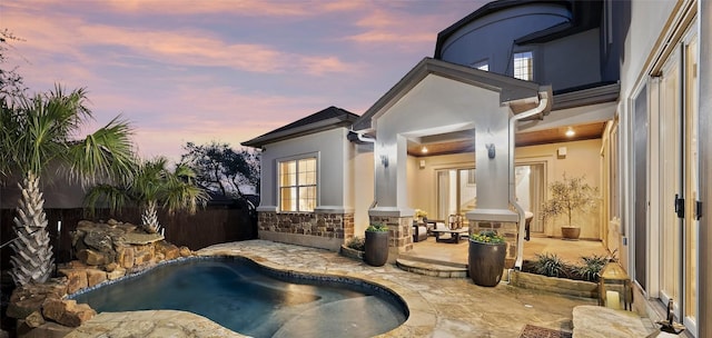 pool at dusk with a patio