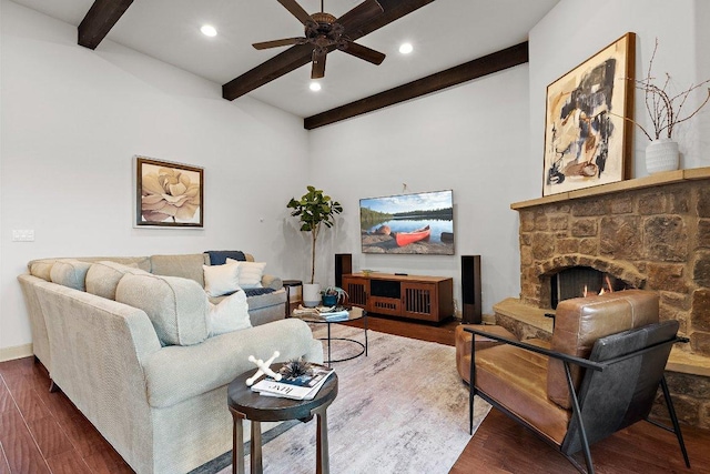 living area featuring beamed ceiling, a ceiling fan, and wood finished floors