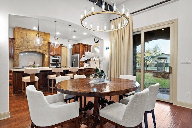 dining room featuring baseboards, visible vents, wood finished floors, and a notable chandelier