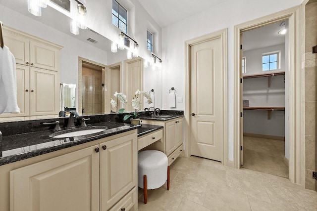 full bathroom featuring visible vents, tile patterned flooring, double vanity, and a sink