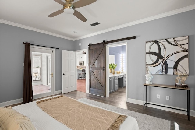 bedroom with a barn door, wood finished floors, and crown molding